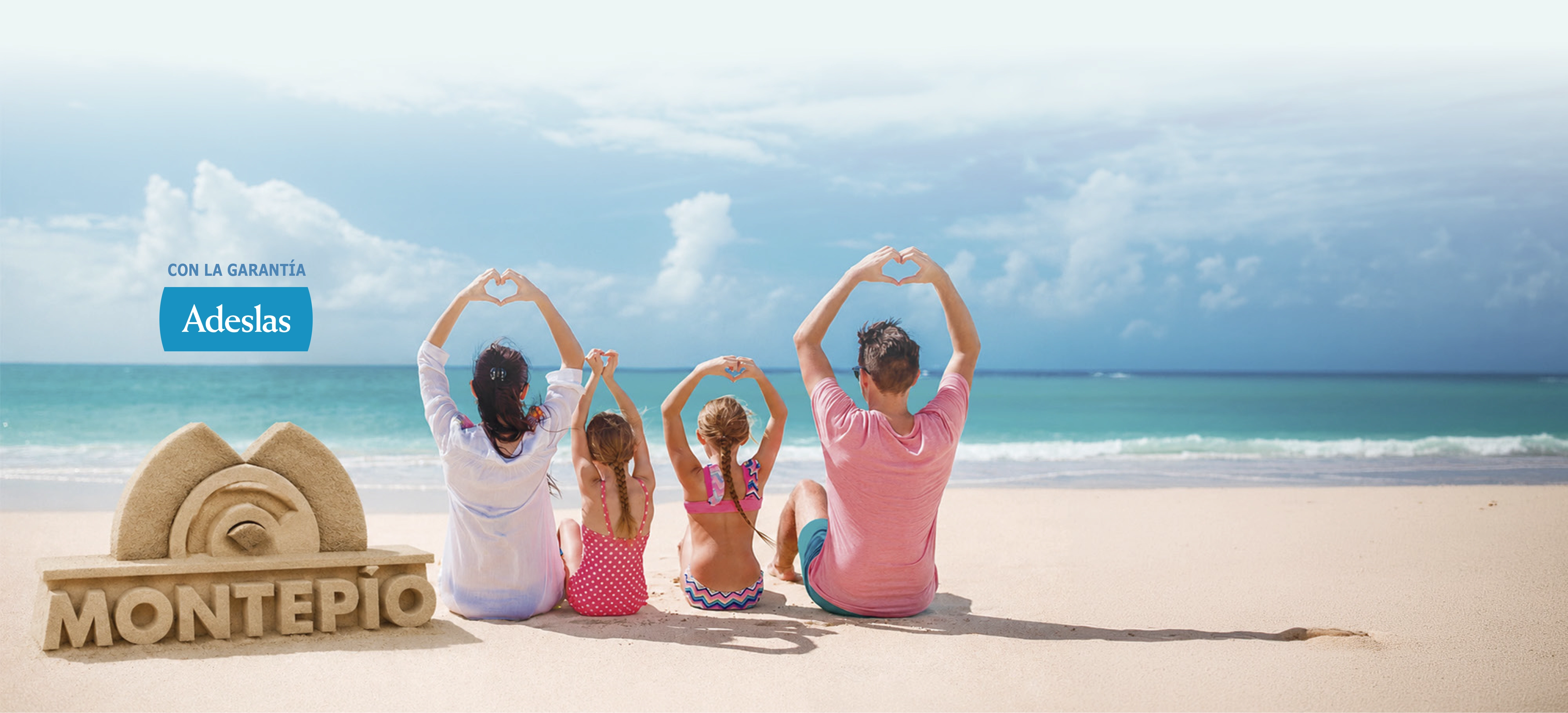 Familia en la playa junto a una figura de arena de Montepio